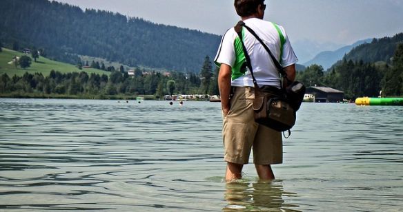 Mann mit kurzen Hosen steht im Wasser