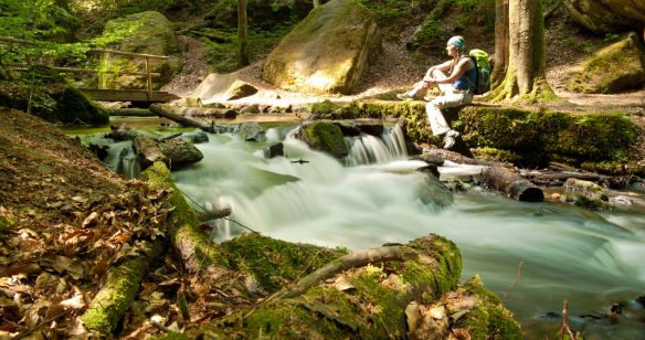 Wanderin entspannt an einem See im Wald