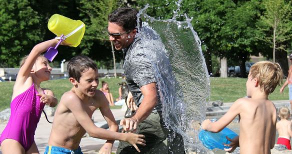 Kinder und erwachsener Mann beim spielen mit Wasser