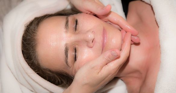 Frau bekommt eine Gesichtshautmassage und genießt diese