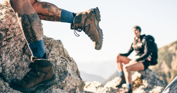 Beine eines Wanderers der Wandersocken in seinen Wanderschuhen trägt.