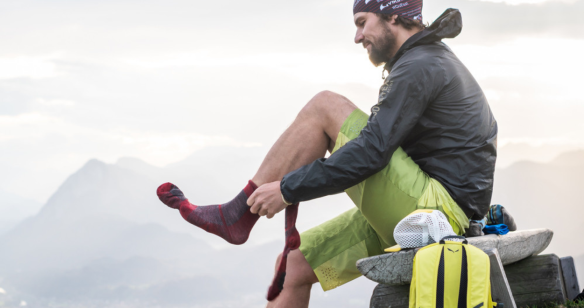 Wanderer in der Natur zieht sich Wandersocken an