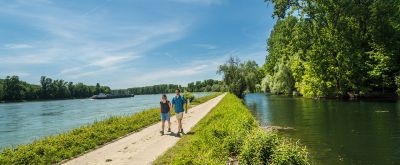 Zwei Wanderer auf dem Treidlerweg, der Weg geht zwischen zwei Seen