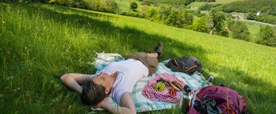 Frau picknickt auf einer Idyllischen Wiesen am Remigius Wanderweg