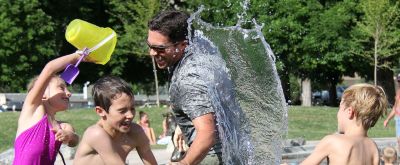 Kinder und erwachsener Mann beim spielen mit Wasser