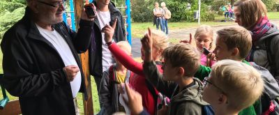 Geocaching Neidenfels Zwei Männer beim Geocaching in Neidenfels erklären Kindern etwas