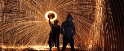 Feuerwerk Mann macht Feuerwerkringe während ein zweiter daneben steht