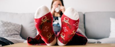 Entspannte Frau Entspannte Frau trinkt Tee und hat Renntierkuschelsocken an