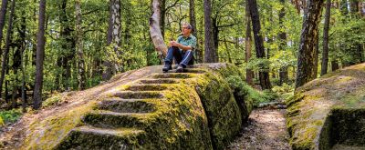 Treppenfelsen Ganerbenweg Wanderer ruht sich auf Treppenfelsen aus