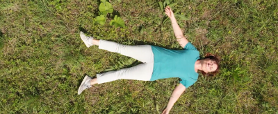 Yogalehrerin liegt entspannt auf einer Lichtung im Wald