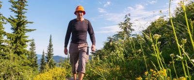 Kleidung mit UV-Schutz Wanderer mit Sonnenhut und UV-Shirt in der Natur