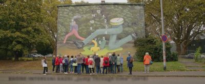 Die Teilnehmer der Mural Wanderung schauen sich eines der Kunstwerke von Stadt.Wand.Kunst. in Mannheim an