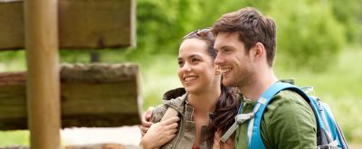 Wandern in der Pfalz Zwei Wanderer schauen im Wald auf einen Wegweiser