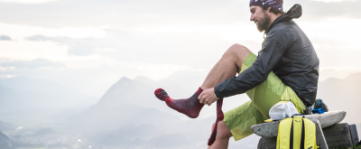 Wanderer in der Natur zieht sich Wandersocken an