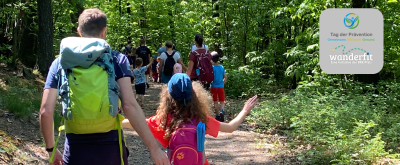 Mehrere Familien wandern gemeinsam im Wald