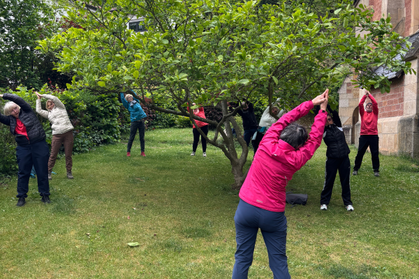 Wanderer machen Yoga im Kirchgarten