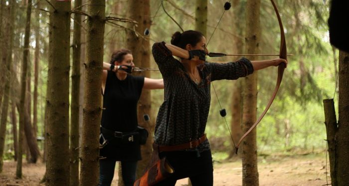 Zwei Frauen beim Bogenschießen im Wald